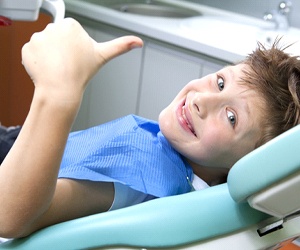 Boy gives thumbs up to Plano dentist after fluoride treatment