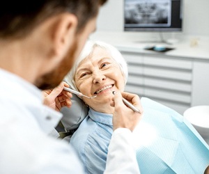 senior woman smiling at her dentist