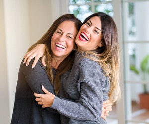 two women smiling and hugging