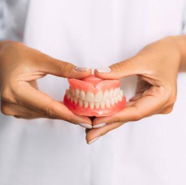 Lady presents viewer with dentures