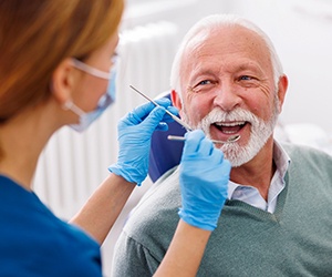 A dentist checking a senior dental patient