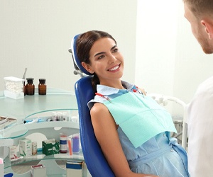 A young woman smiling at her dentist while preparing for a regular dental checkup