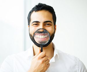 man showing off his smile with dental crowns in Plano 