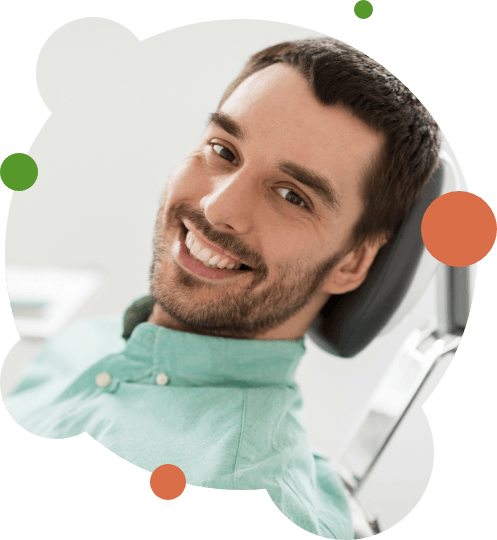 Bearded dental patient sitting back in dental chair and smiling