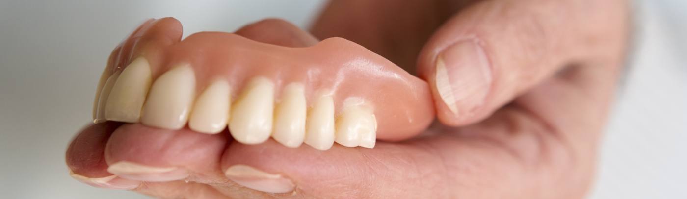 a woman smiling with dentures in Plano