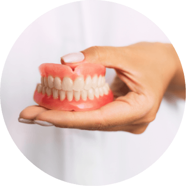 Hand holding pair of full dentures