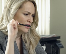Woman chewing on pencil while working