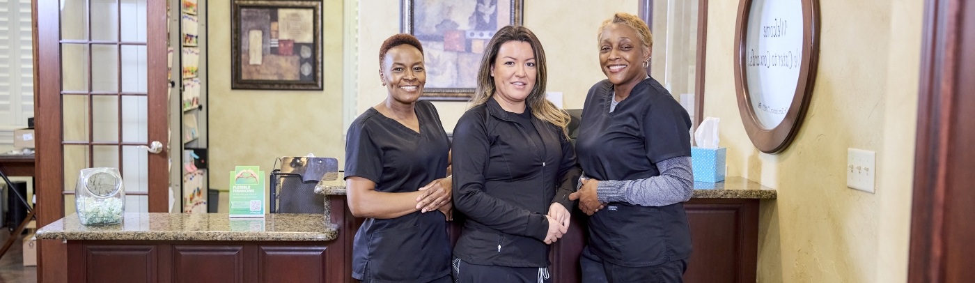 Dental team standing in row and smiling