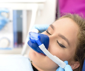 Woman breathing in nitrous oxide at dentist visit