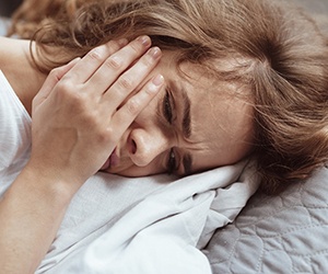 woman toothache in bed for root canal therapy in Plano 