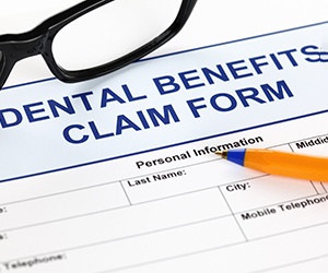 Dental benefits claim form with glasses and pen
