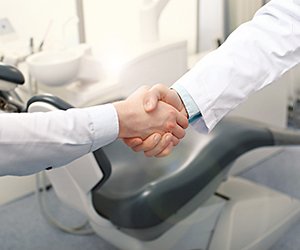 Close-up of dentist shaking hands with patient