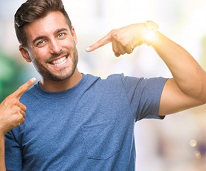 man pointing to his smile after teeth whitening in Plano 