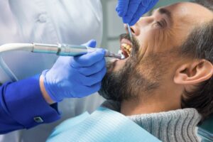 Patient getting teeth cleaned at dentist's office. 