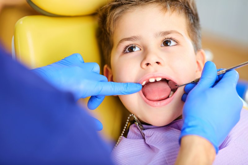 A dentist examining a child’s mouth during a dental visit