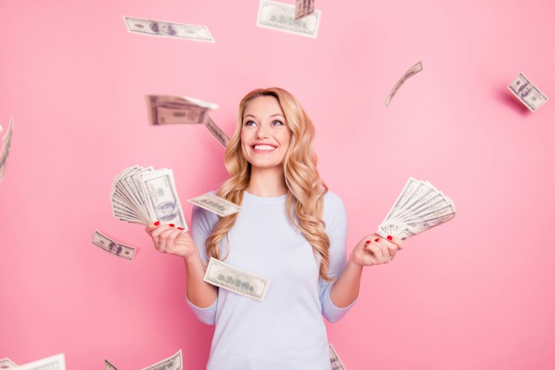 smiling woman standing in a room filled with falling money