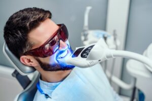 Young man having teeth professionally whitened. 