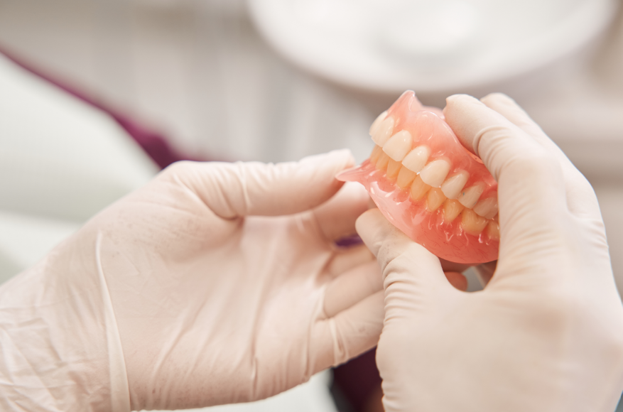 Dentist holding dentures